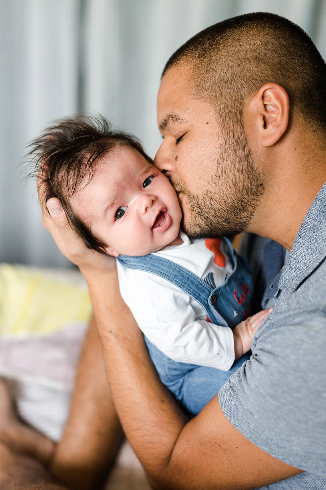 papa qui fait un bisou sur la joue du bébé