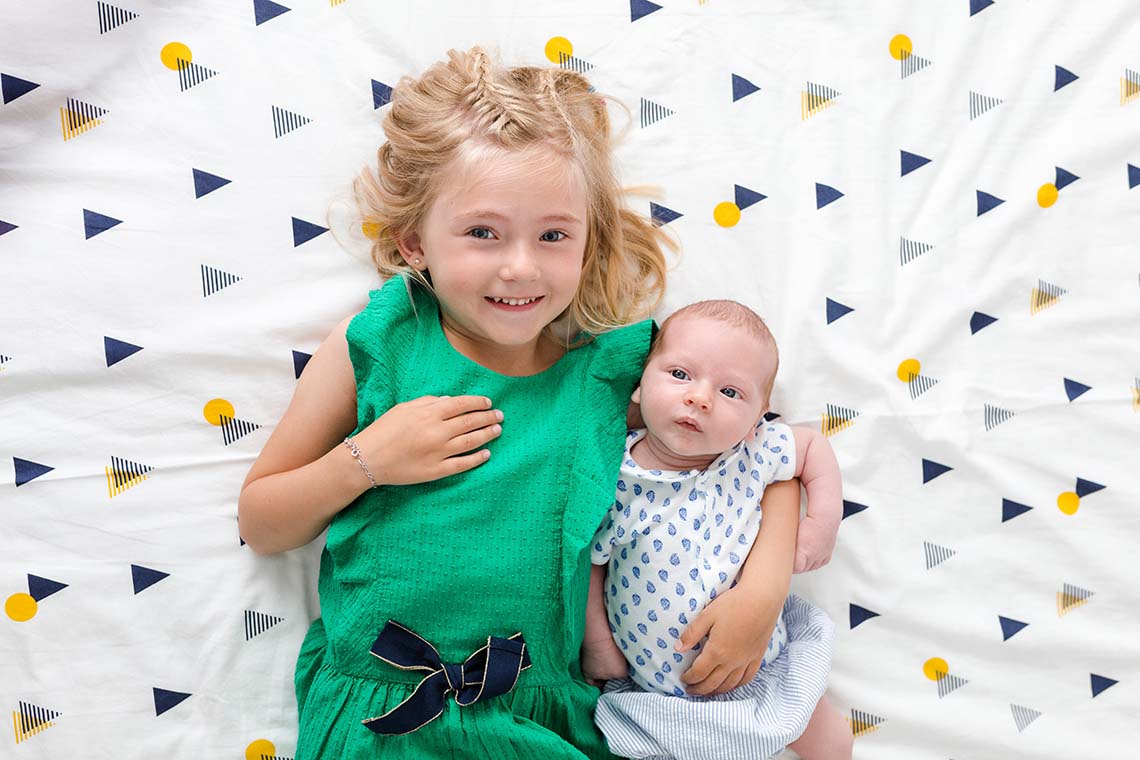 bébé et ainé sur le lit
