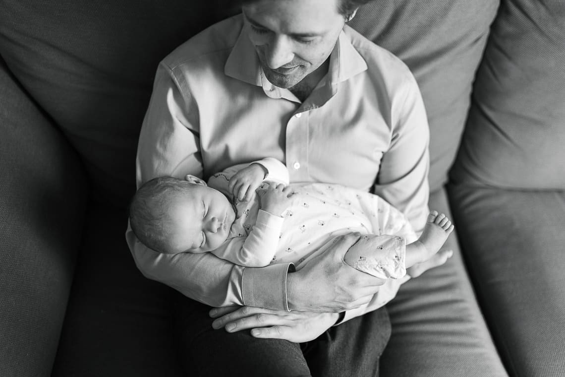photo de papa et son bébé en noir et blanc sur le canapé admiration